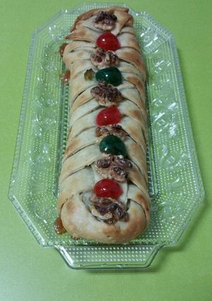 Una foto de Trenza de masa brisa rellena de membrillo y adornada con nueces y cerezas confitadas