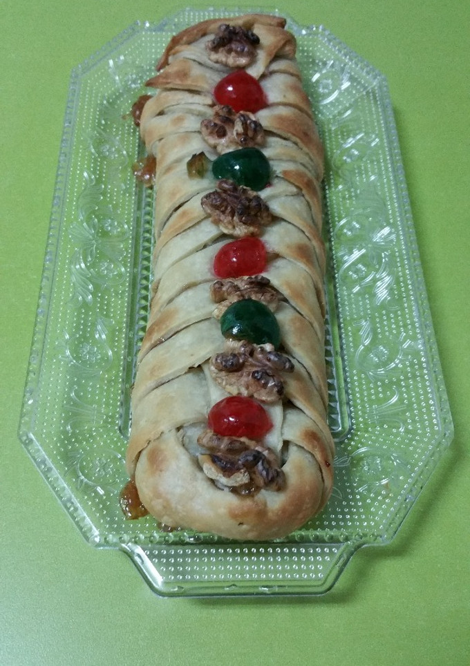 Una foto de Trenza de masa brisa rellena de membrillo y adornada con nueces y cerezas confitadas