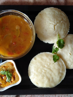 A picture of Idli sambhar with chutney.