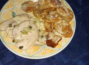 Una foto de Pechugas de pollo con salsa de verdeo y papitas al horno