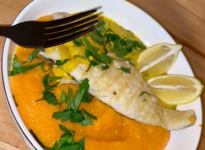 Une photo de Merlu 🐟 & sauce curcuma-citron 🍋 avec une purée de carottes 🥕