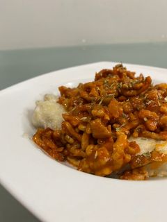 Una foto de Ñoquis caseros rellenos de mozzarella en salsa boloñesa