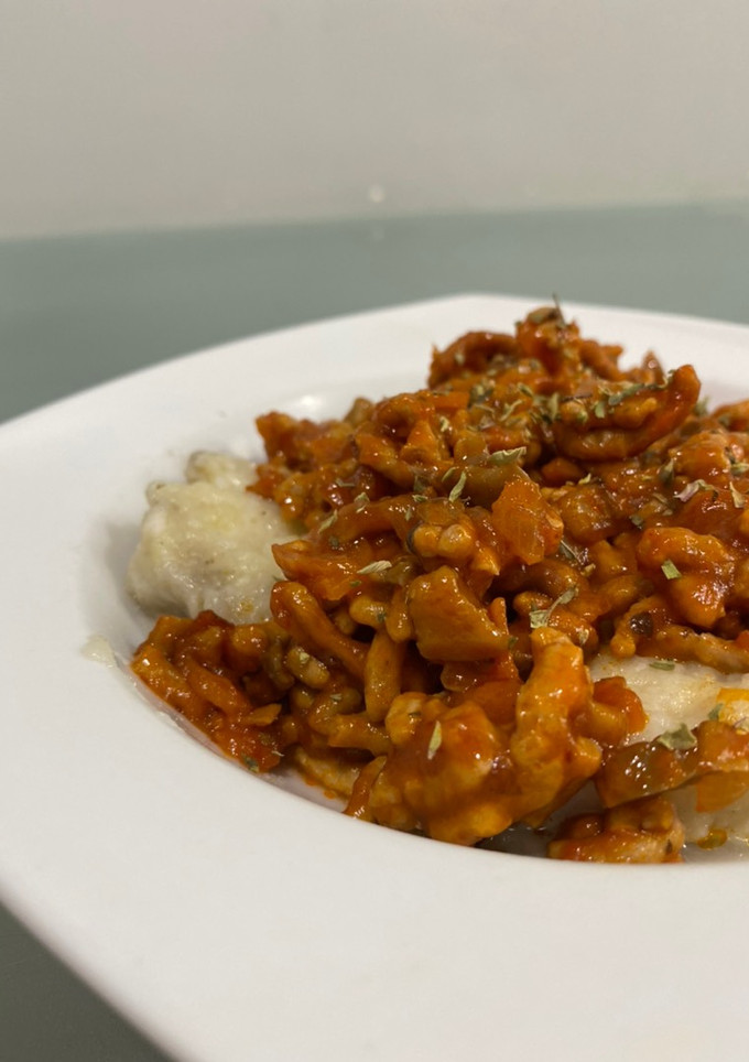 Una foto de Ñoquis caseros rellenos de mozzarella en salsa boloñesa