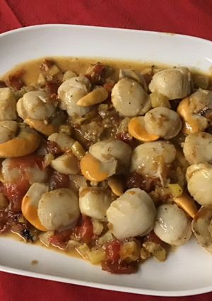 Une photo de Noix de saint Jacques à l'ail, tomate et citron confit