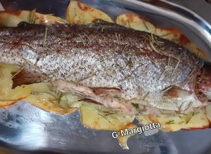 Foto di Trota al forno, farcita con spezie su letto di patate