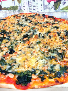 Una foto de Pizza de espinacas y queso con piñones