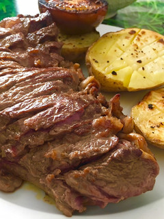 Una foto de Entrecot a la plancha con patatas y tomate asado