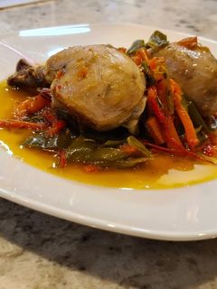 Una foto de Muslos de pollo guisados con pimientos, zanahorias y romero