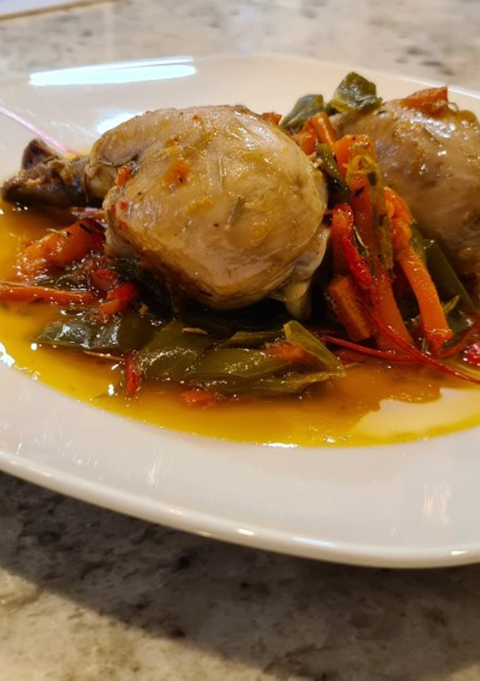 Una foto de Muslos de pollo guisados con pimientos, zanahorias y romero