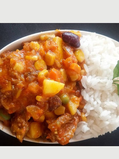 A picture of White rice with pepper chicken vegetable sauce.