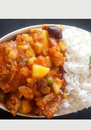 A picture of White rice with pepper chicken vegetable sauce.