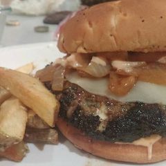 A picture of Beef, Lamb and Feta Burger with Provolone, Caramelized Onions and Russian Horseradish Dressing served with Garlic Fries.