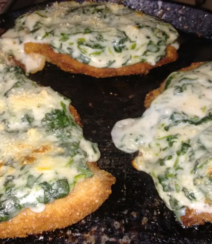 Una foto de Milanesas con salsa blanca y espinaca