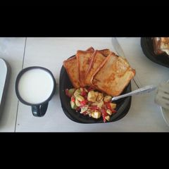 Toasted bread with kachumbari served with white coffee A picture of Toasted bread with kachumbari served with white coffee.
