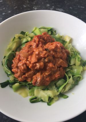 A picture of Bacon and mushroom sauce with courgette ribbons.