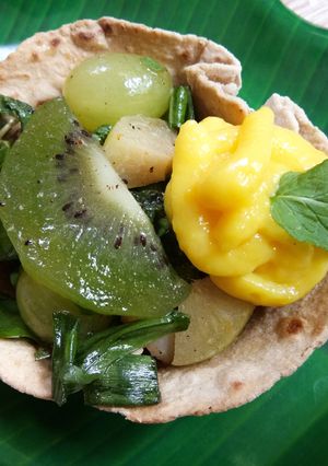 A picture of Green salad with custard in tortilla cups.