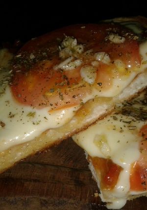 Una foto de Pizza casera de tomate y ajo