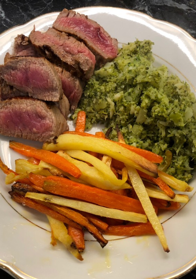 A picture of Steak with brocolli mash and parsnip/carrot fries.