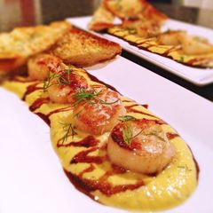 A picture of Sea scallops, tarragon butternut squash purée, honey balsamic reduction and truffled parmesan toast.