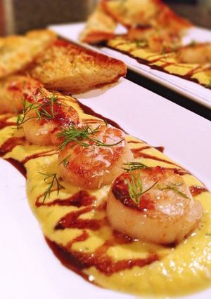 A picture of Sea scallops, tarragon butternut squash purée, honey balsamic reduction and truffled parmesan toast.