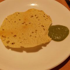A picture of Papad and mint curd Chutney.