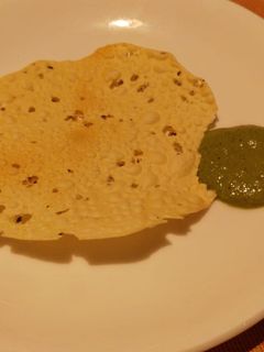 A picture of Papad and mint curd Chutney.