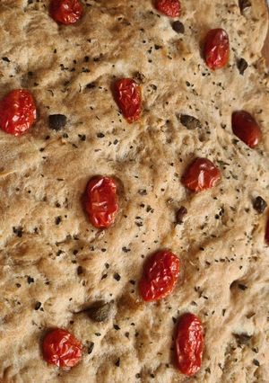 O poză a rețetei Focaccia cu măsline verzi și roșii cherry.