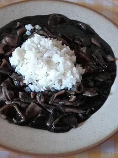 Una foto de Chipirones en tinta, y arroz blanco