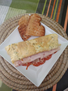 Una foto de Tortilla sándwich de tomate, queso y pavo