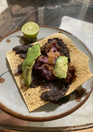 Una foto de Tostadas con frijoles negros fritos en manteca de Puerco 🐷