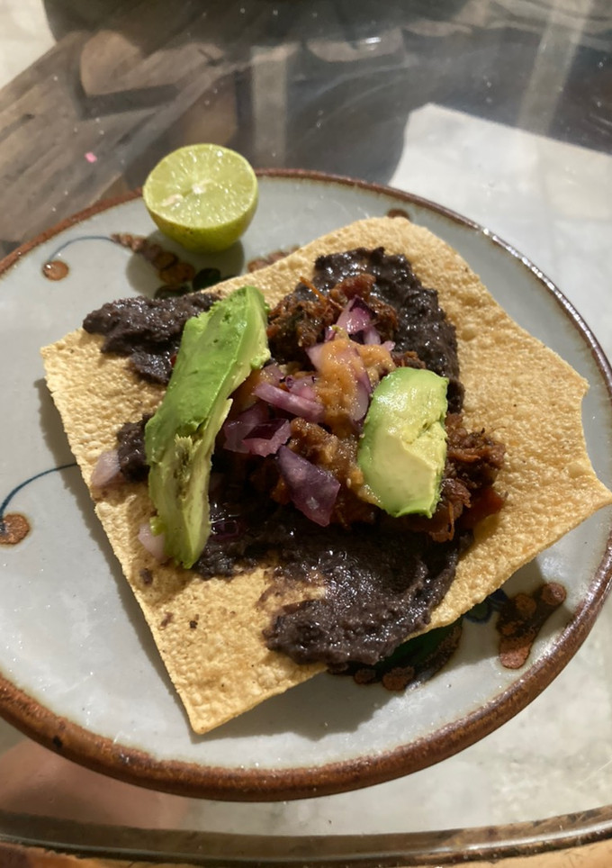 Una foto de Tostadas con frijoles negros fritos en manteca de Puerco 🐷