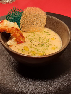 Una foto de Langostino marinado en crema de poroto con cáscara de limón