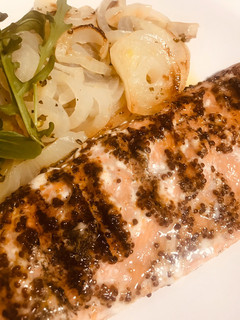 Una foto de Salmón salvaje marinado, a las brasas, con cebolla en paquetito