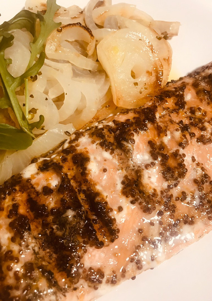Una foto de Salmón salvaje marinado, a las brasas, con cebolla en paquetito