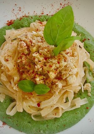 Una foto de Noodles fritos con huevo y atún sobre crema de espinacas y setas