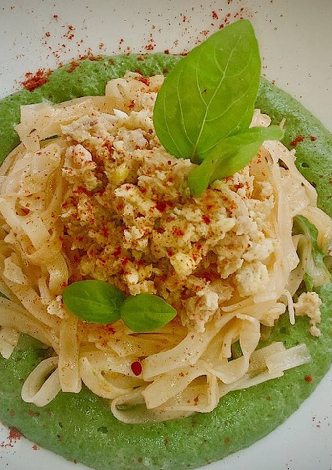 Una foto de Noodles fritos con huevo y atún sobre crema de espinacas y setas