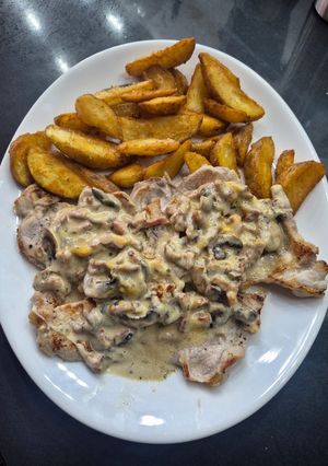 Una foto de Chuletas de cerdo con salsa de champiñones y crujiente de bacon