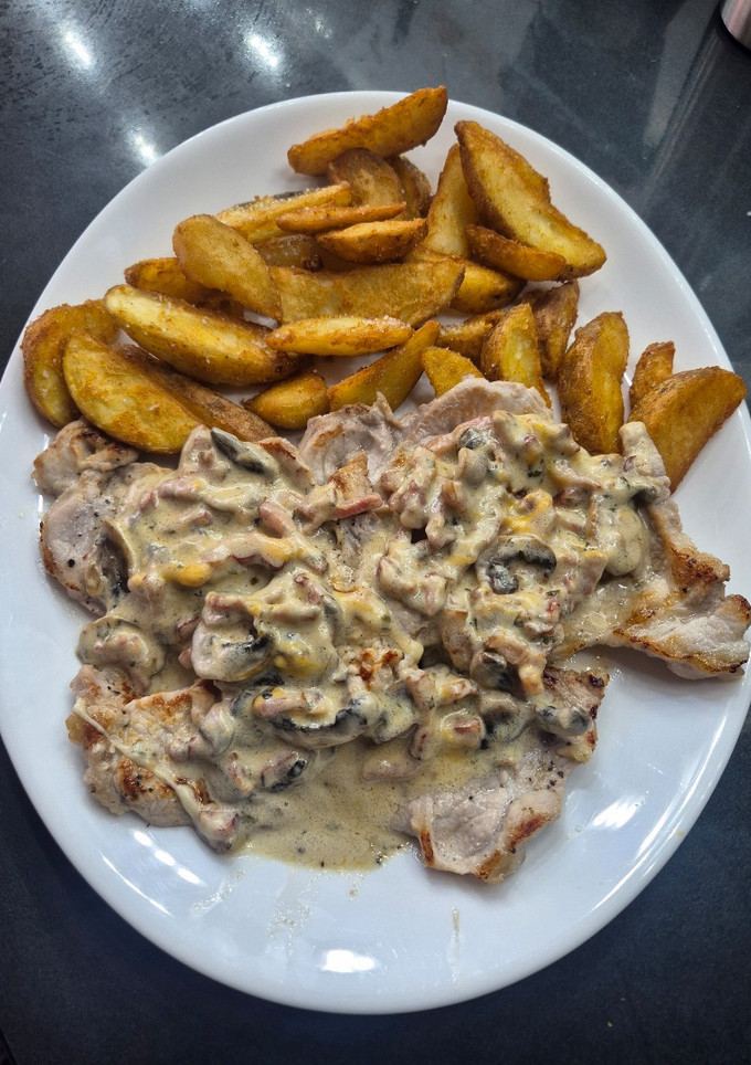 Una foto de Chuletas de cerdo con salsa de champiñones y crujiente de bacon