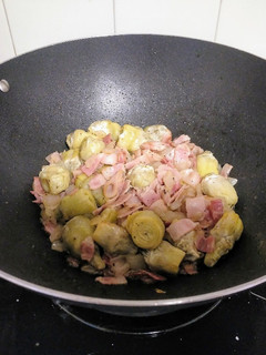 Una foto de Wok de alcachofas baby con cebolla y bacon
