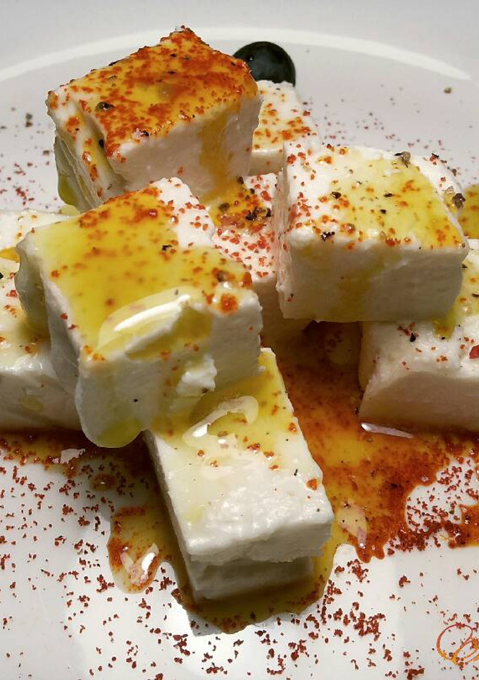 Una foto de Queso fresco de cabras, con pimentón y aceite picante de guindillas verdes