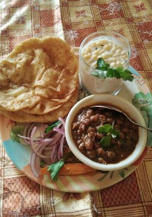 A picture of Panjabi chole bhature onion and Bundi ka Raita.