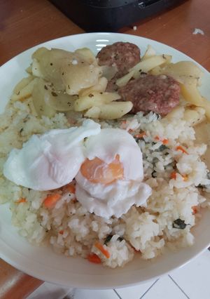 Una foto de Arroz con verduras, papas y cebolla cocidas, hamburguesas caseras y huevo ponchado