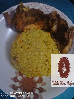 A picture of Tumeric Jallop Rice with chicken wings.
