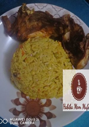 A picture of Tumeric Jallop Rice with chicken wings.