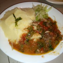 A picture of Mashed potatoes with beef stew.