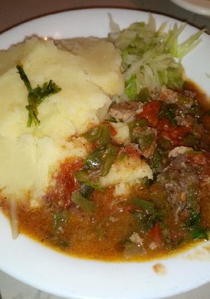 A picture of Mashed potatoes with beef stew.
