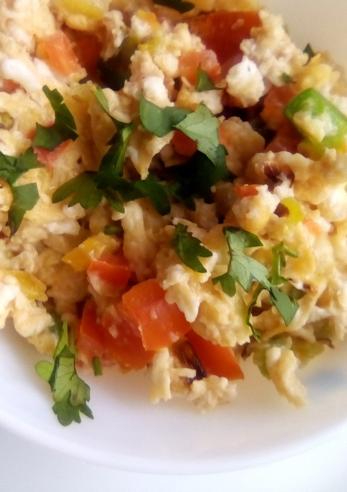 A picture of Simple scrambled eggs with onions, tomatoes and capsicum.
