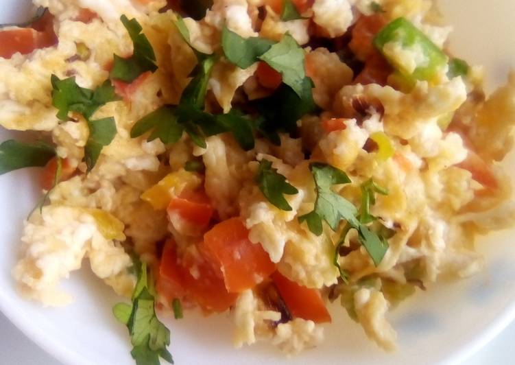 Simple scrambled eggs with onions, tomatoes and capsicum