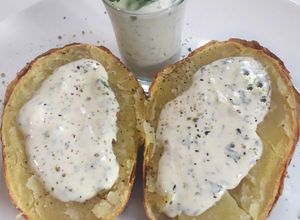Una foto de Patatas asadas, con salsa de nata fresca y cilantro