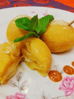 Una foto de Bombas de patata al mojo picón rellenas de queso, al horno